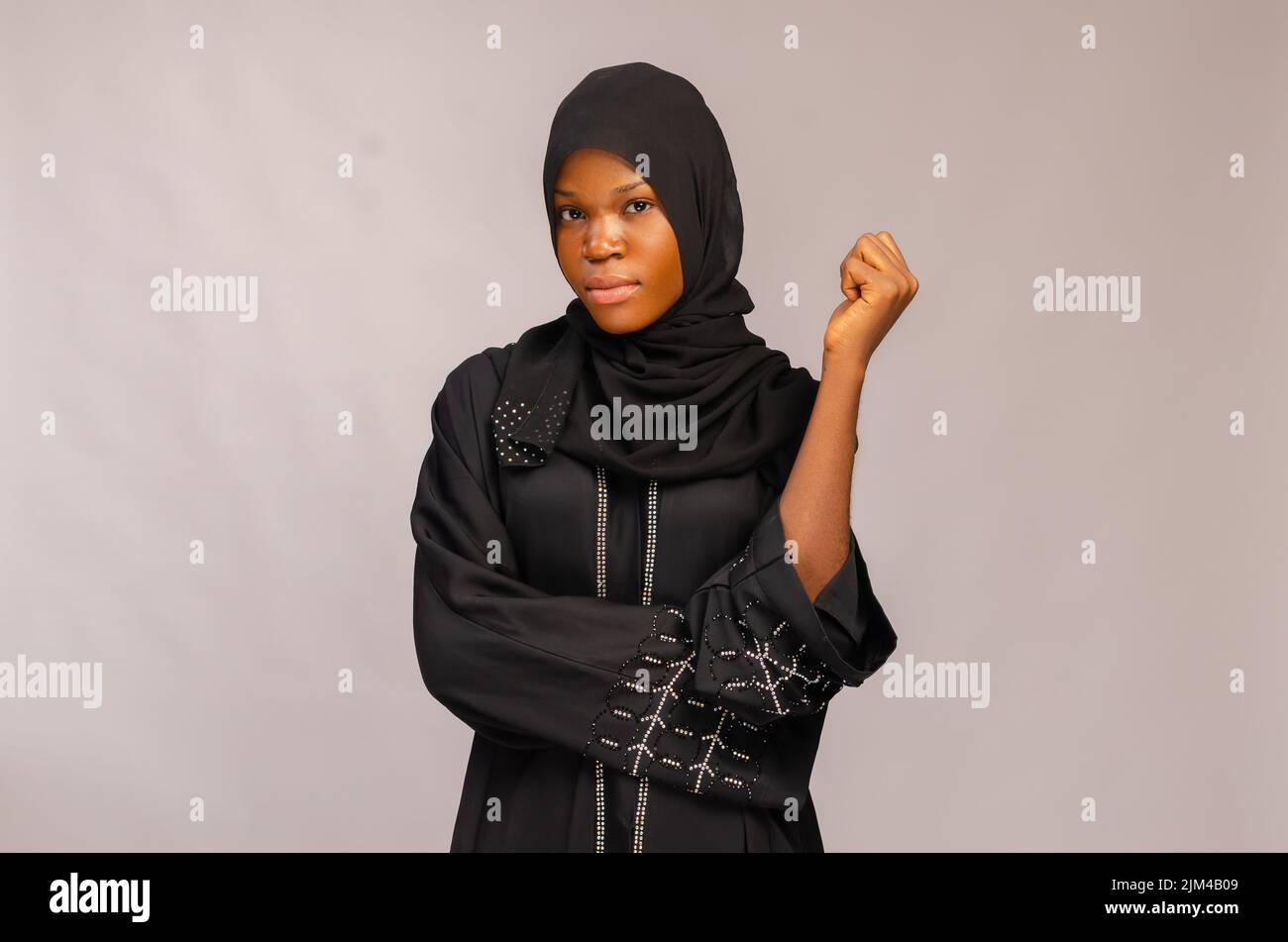 A beautiful African Muslim lady overexcited in a black outfit isolated ...