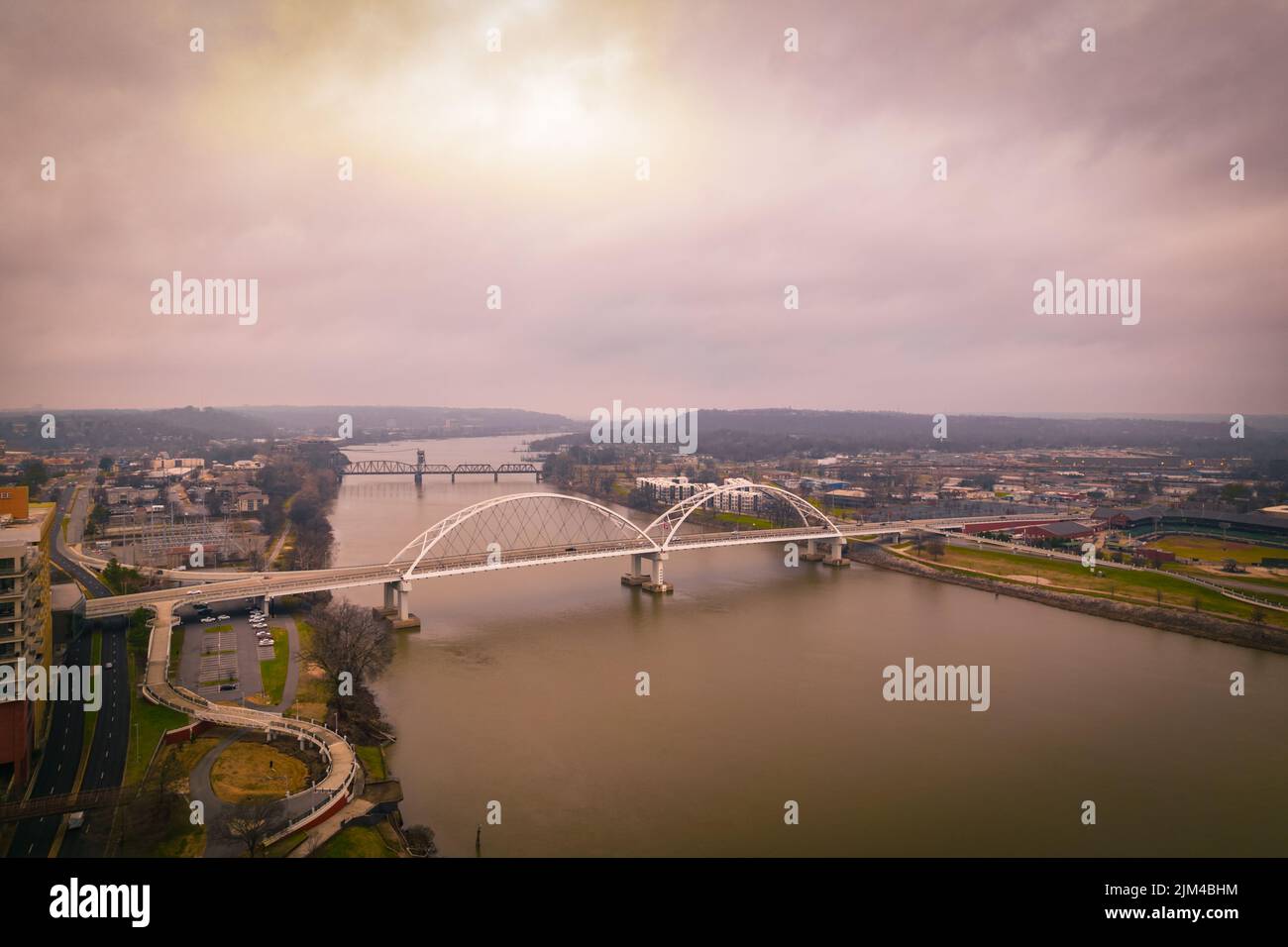 An aerial view of the Broadway Bridge over the river in Pulaski County, Arkansas against a bright sunset cloudy sky Stock Photo