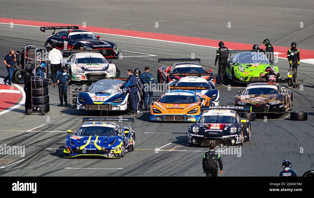A closeup of sports cars on track with many people during motor Sports at the Dubai Autodrome Stock Photo