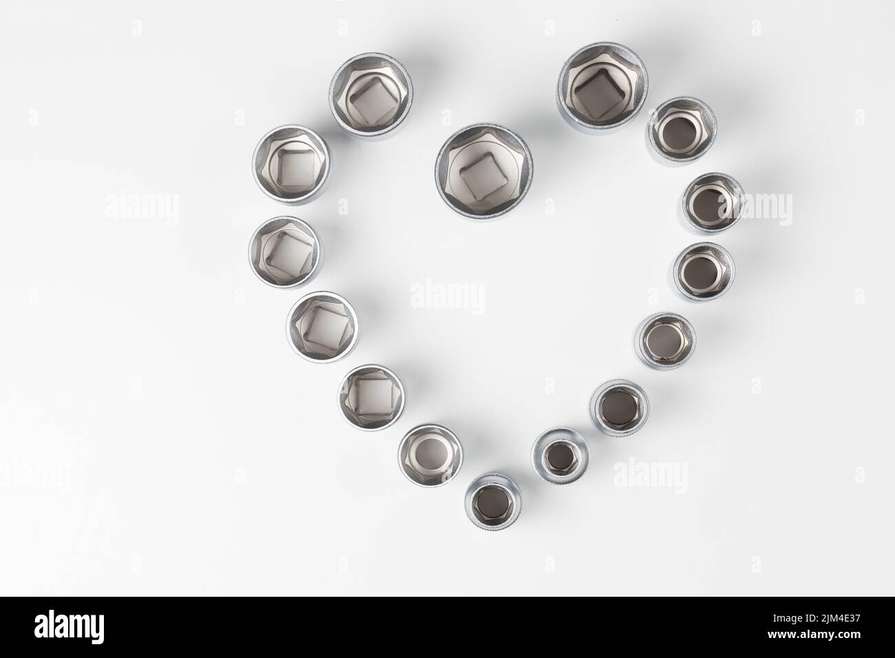 Hexagonal nests of different sizes in the shape of a heart on a white surface Stock Photo