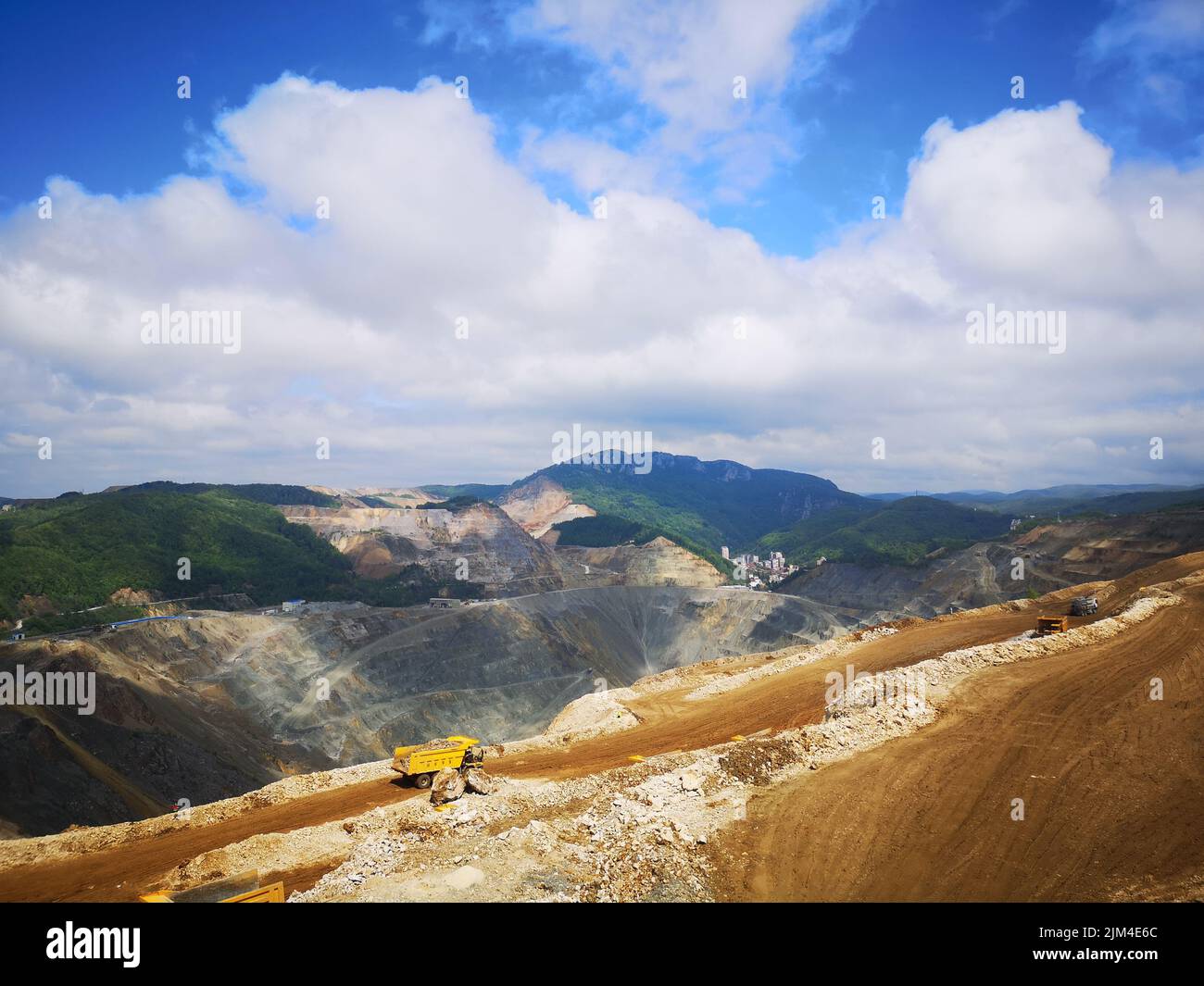 The view of the cars on the mine against the mountains range and blue sky. Majdanpek, Serbia. Stock Photo