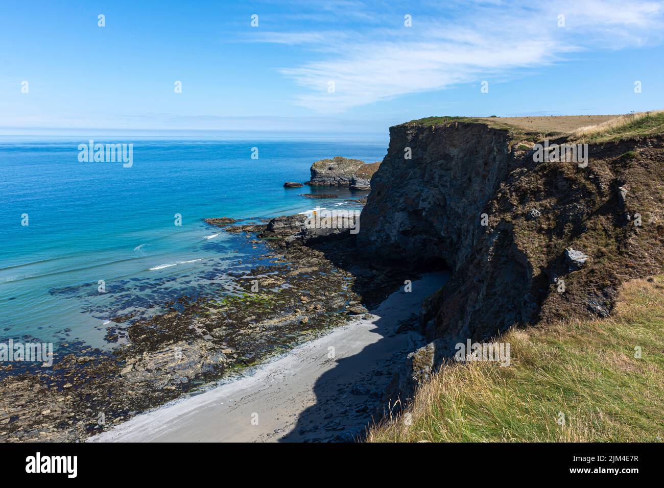 Beautiful bay on the coast of Cornwall.Blue sky over cliff and sea with turquoise water. Stock Photo