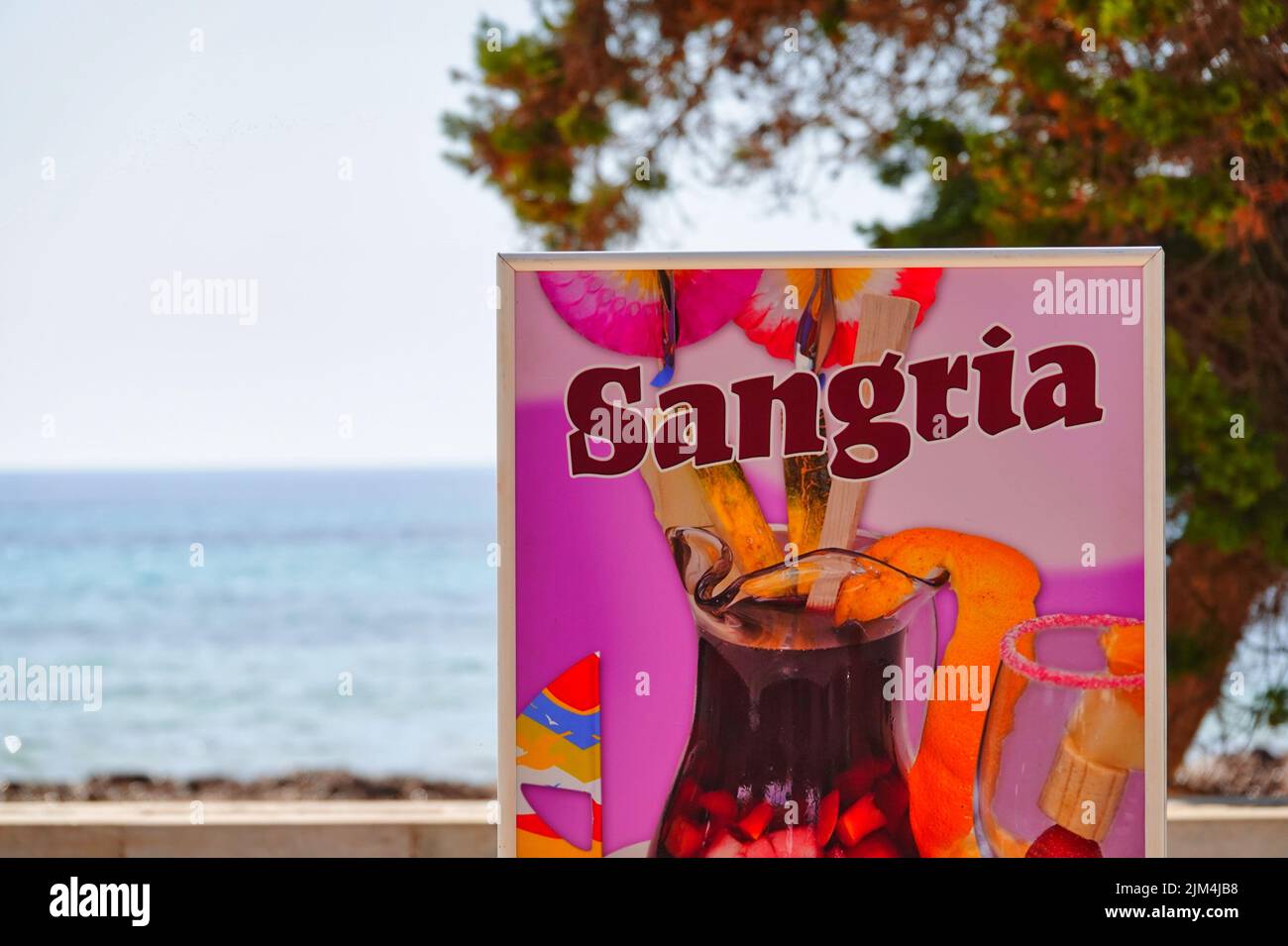 Picture shows an advertising sign for Sangria in Sa Coma, Mallorca, with the sea in the background Stock Photo