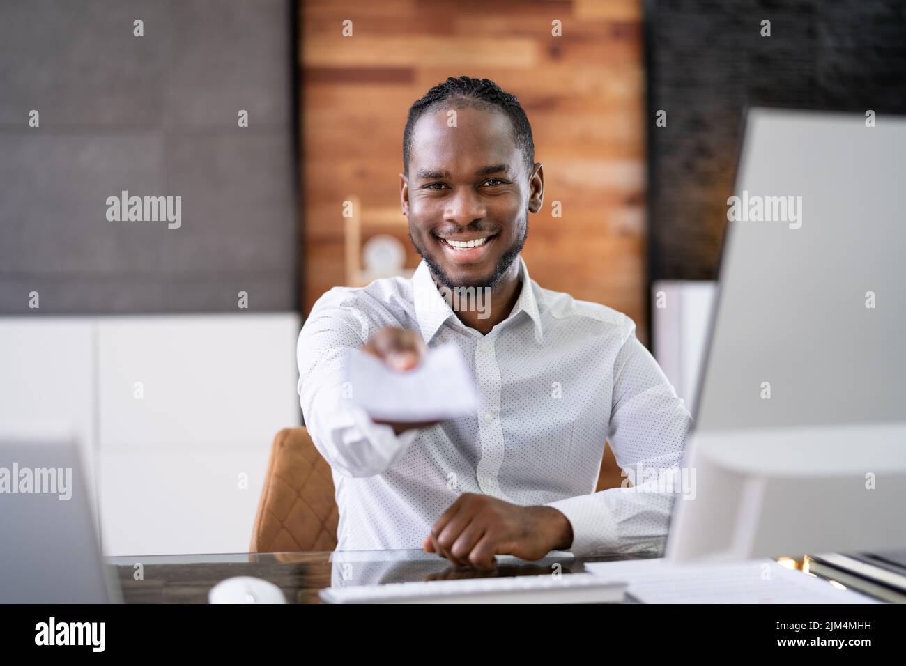African Business Man Giving Paycheck Or Payroll Cheque Stock Photo