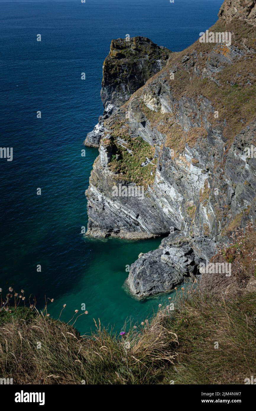 Cliff on the Cornwall coast and beautiful bay with emerald water. Stock Photo