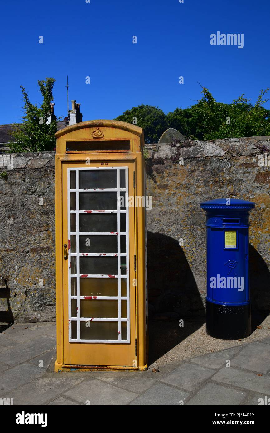 An iconic Yellow telephone box and Blue Post Box, in St Anne's High Street just outside the Alderney Museum,  Alderney, Channel Islands, Great Britain Stock Photo