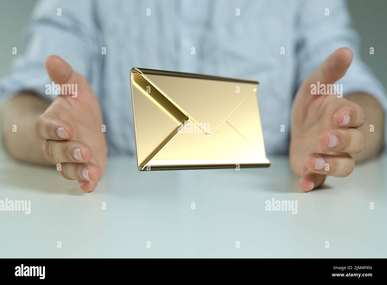 A blurred man holding a gold massage icon concept of the email marketing, sending mail, and newsletter on a white table Stock Photo