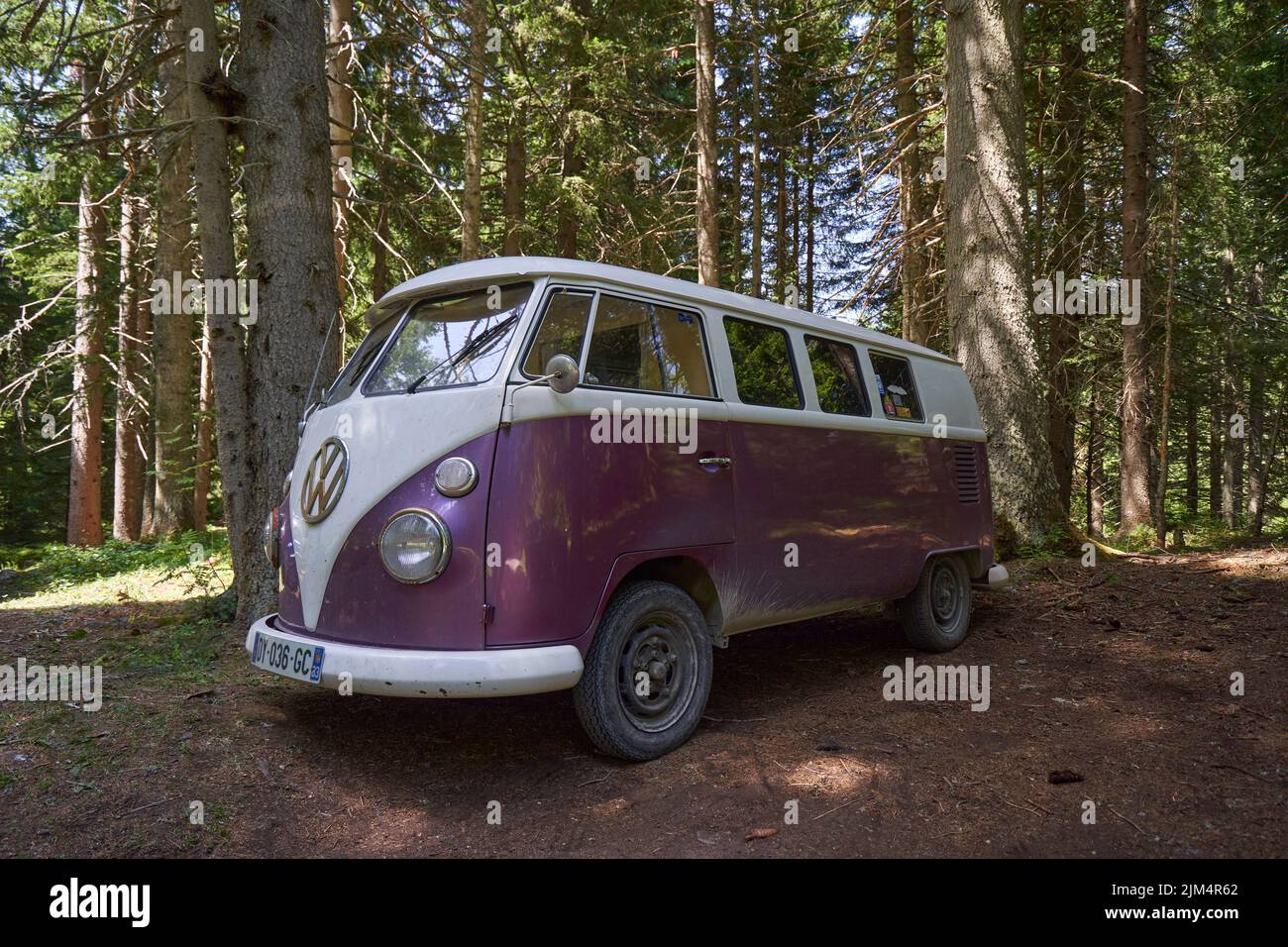 Retro Van of Volkswagen Bulli parked in forest Stock Photo