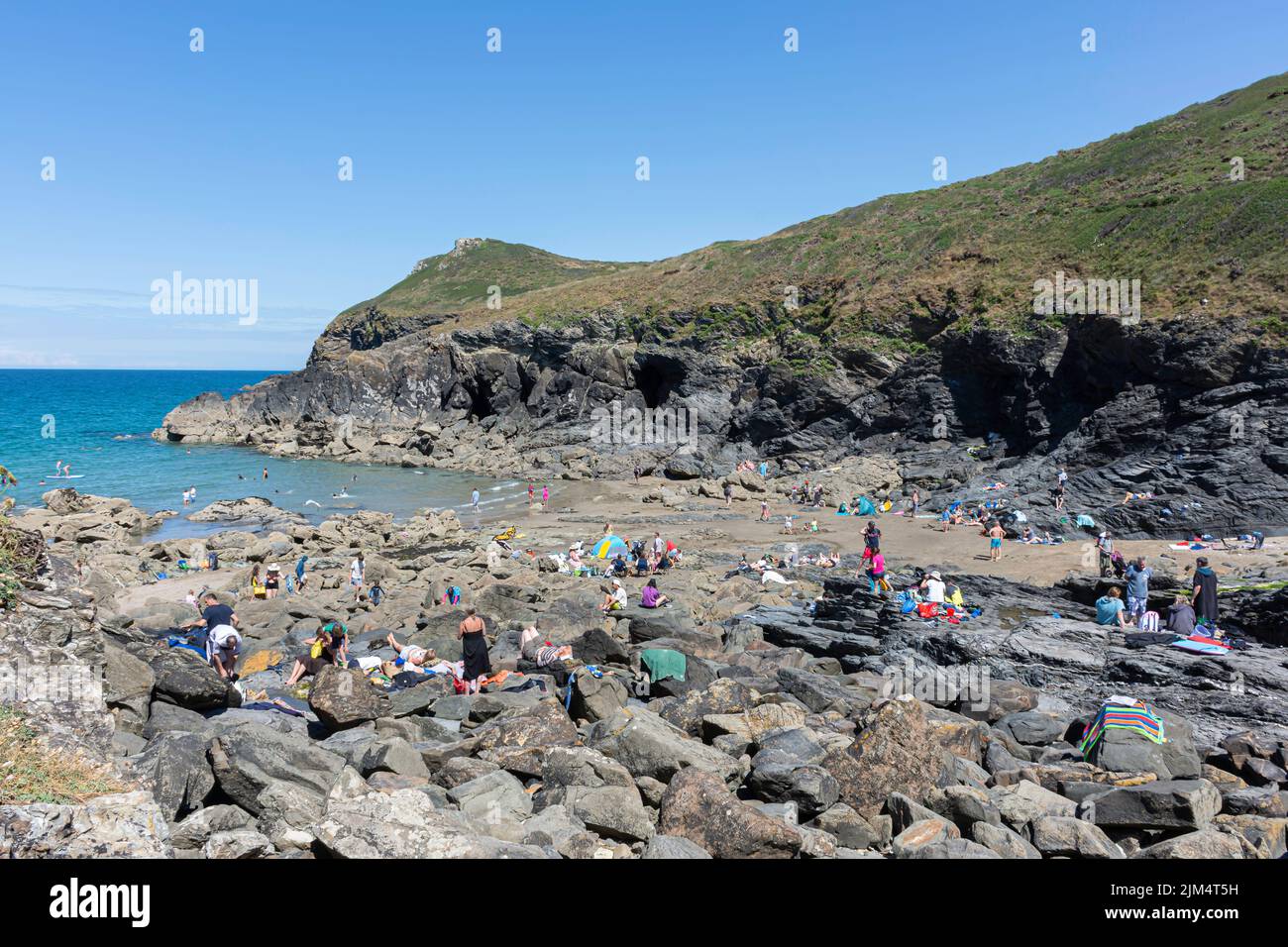 People enjoying beautiful weather on the beach on Cornwall coast. Stock Photo