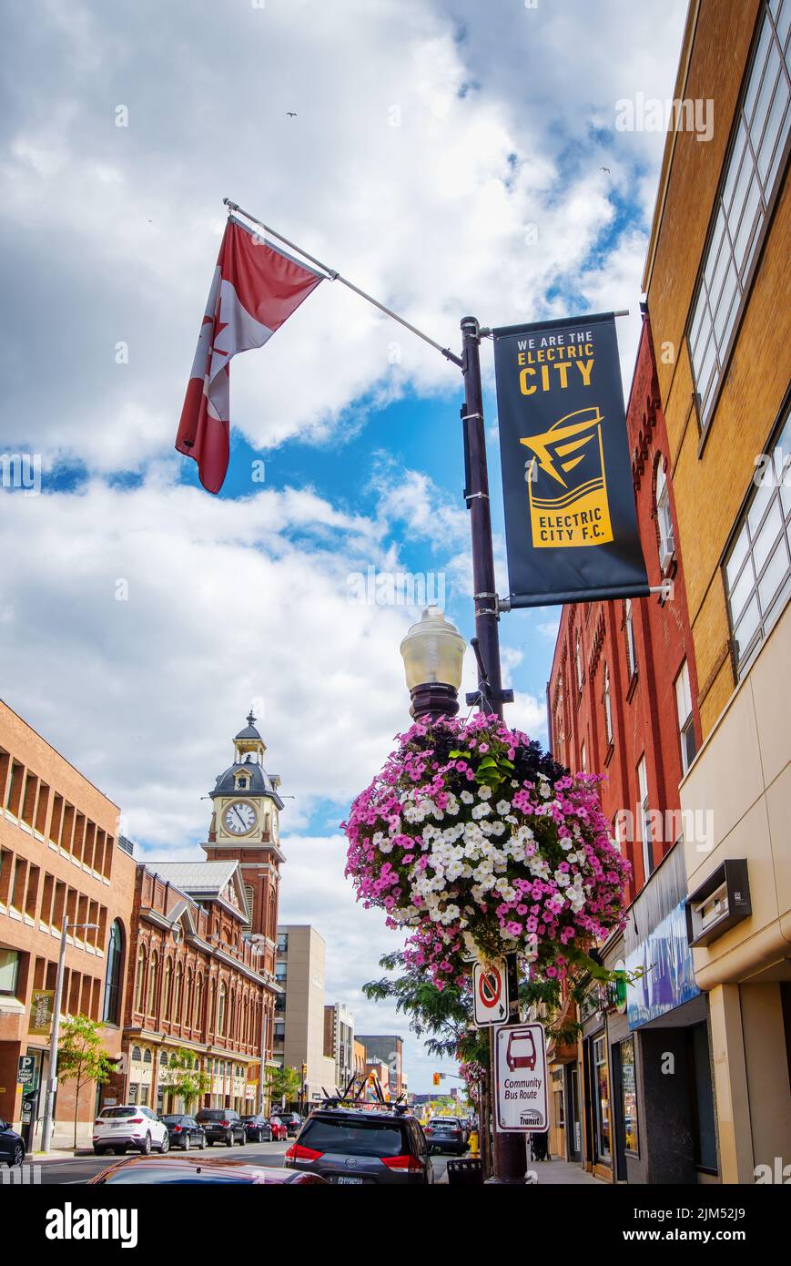 Peterborough Square building, a heritage architecture built in 1889, in downtown with Canadian flag and The Electric City F.C. banner in foreground. T Stock Photo