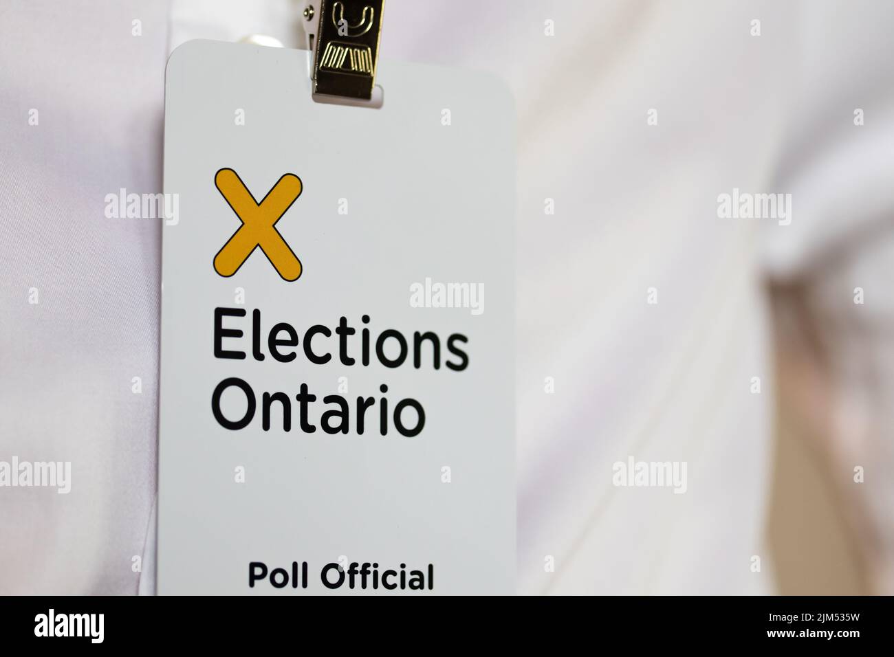 The Election Ontario logo is seen closeup on the badge of a Poll Official working for Elections Ontario. Stock Photo