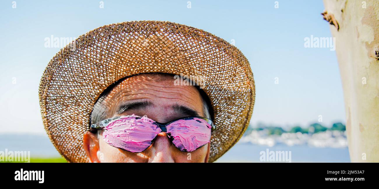 Man with sunglasses covered with pink cream and copy space Stock Photo