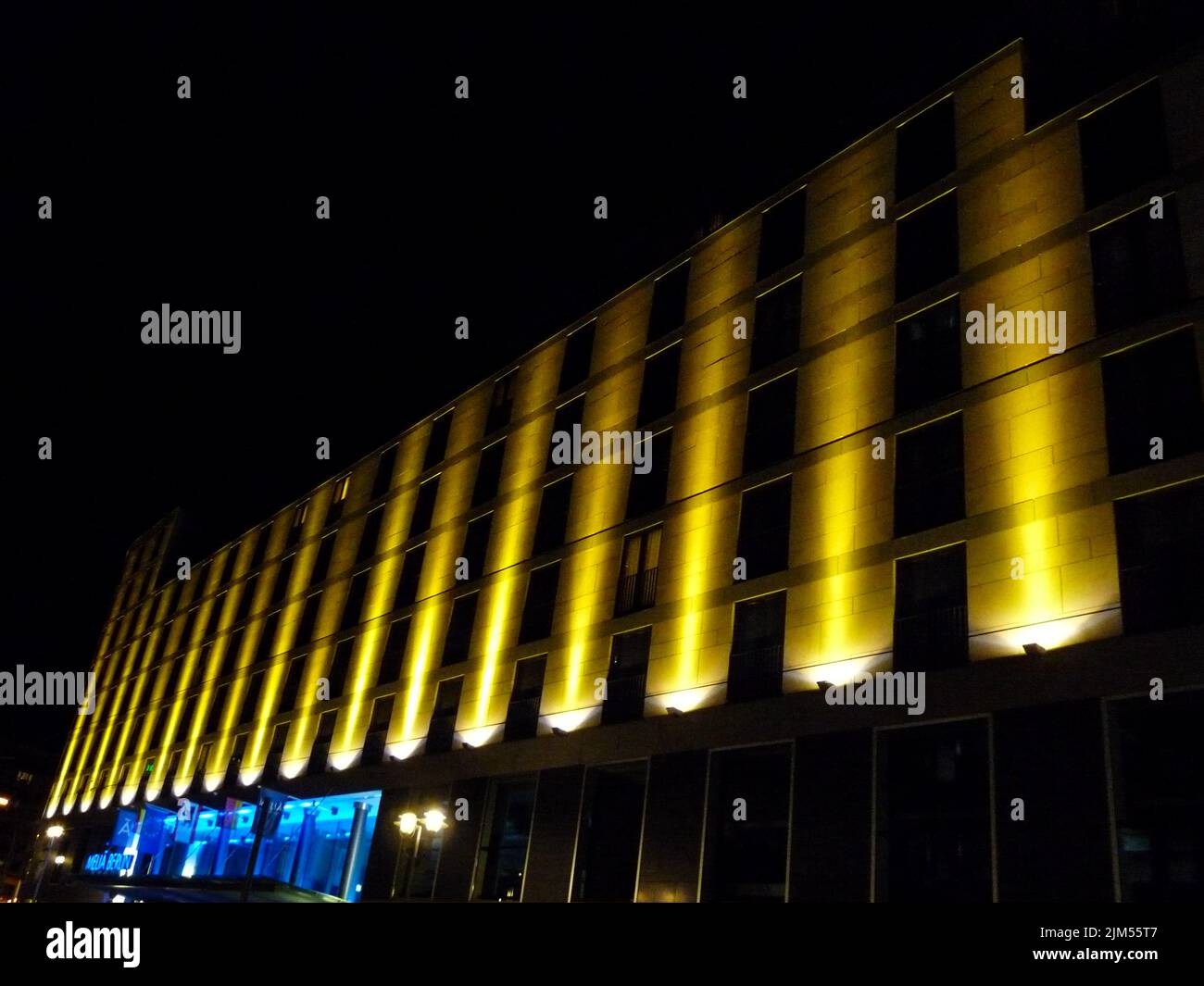 An exterior view of a building illuminated with lights at night in