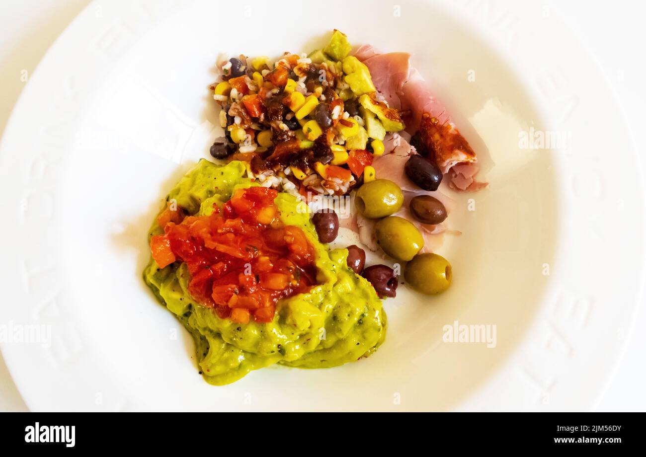 Mixed cold antipasti -- Mexican guacamole, Wiltshire ham, Asian rice salad, Spanish olives Stock Photo