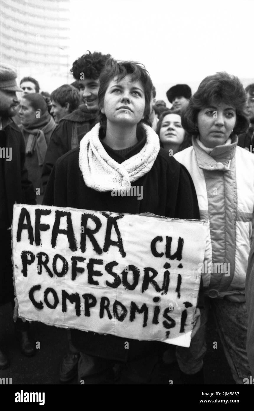 Bucharest, Romania, January 1990. Rally in the University Square following the Romanian Revolution of 1989. People would gather daily to protest the ex-communist officials that grabbed the power after the Revolution. Woman with a sign that says 'Out with the compromised teachers'. Stock Photo