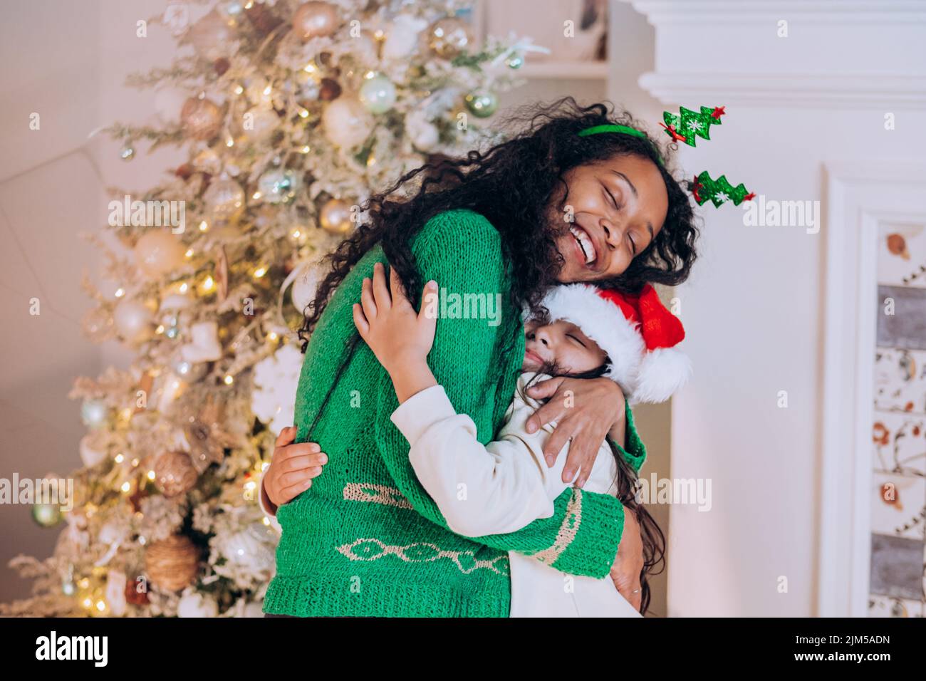 African American woman with curly hair and brunette daughter pose