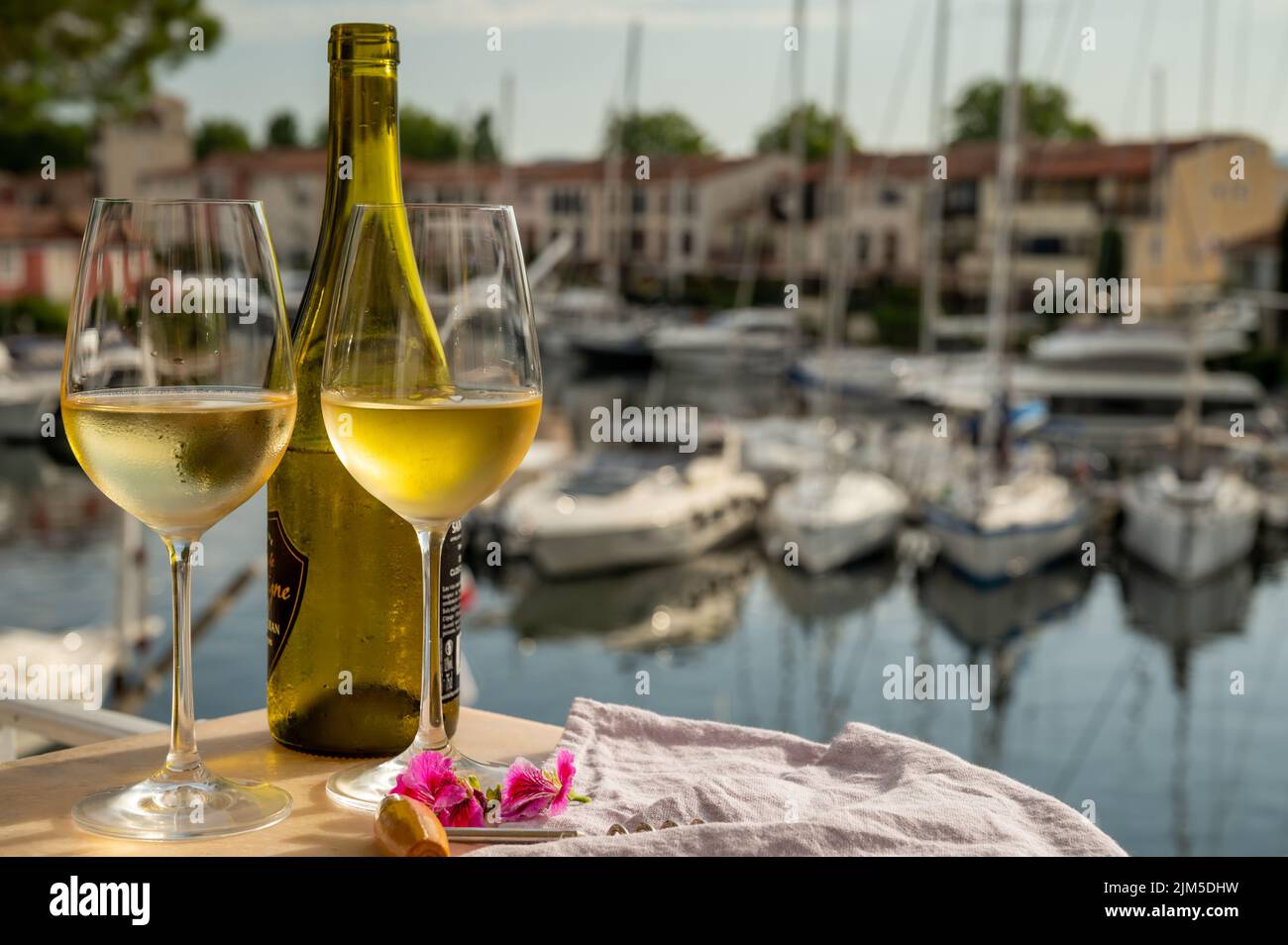 Drinking of cold white wine with view on yacht harbour of Port Grimaud