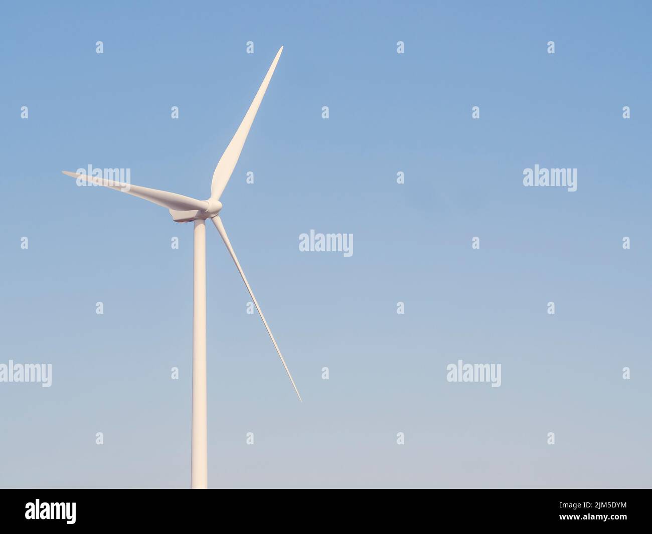A view of a wind turbine in a blue sky background Stock Photo - Alamy