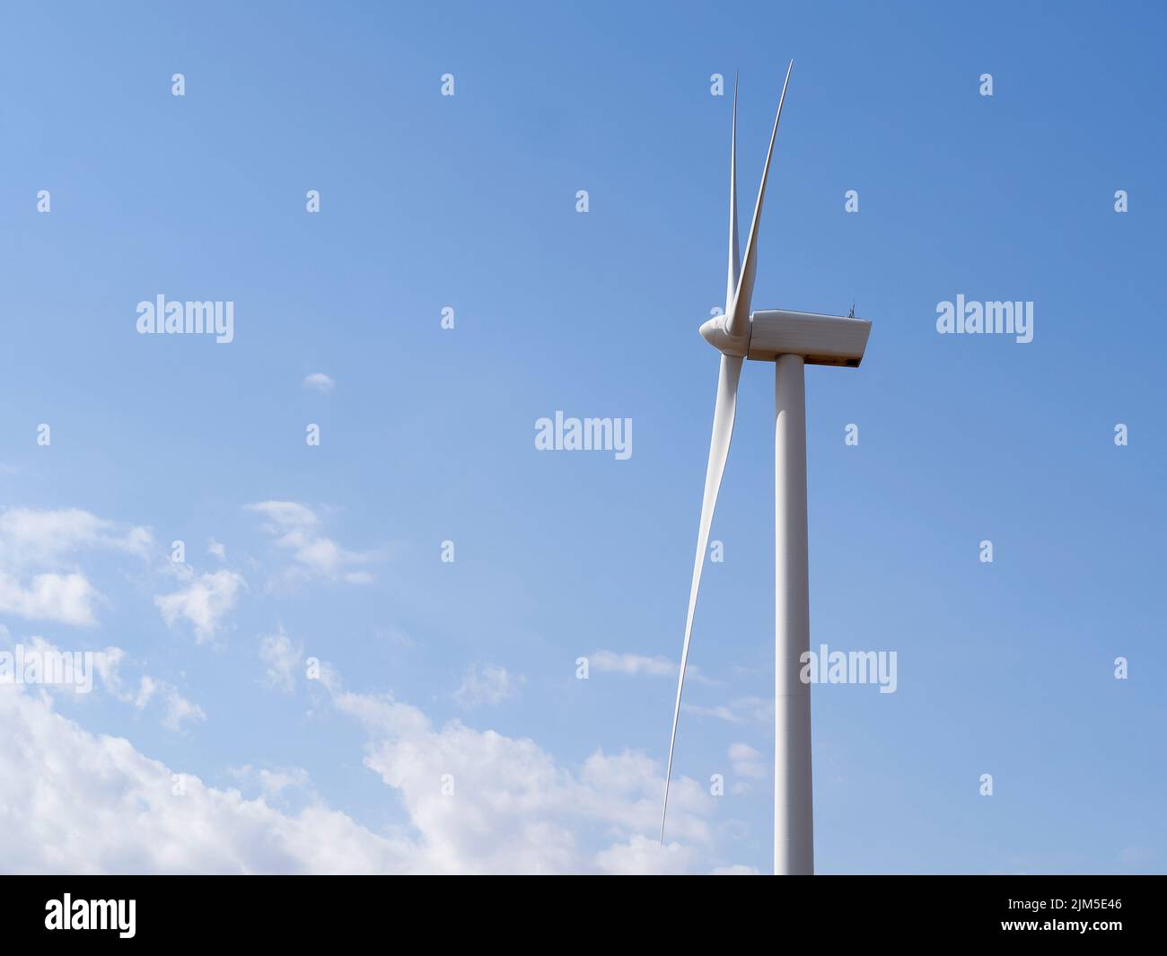 A view of a wind turbine in a blue sky background Stock Photo - Alamy