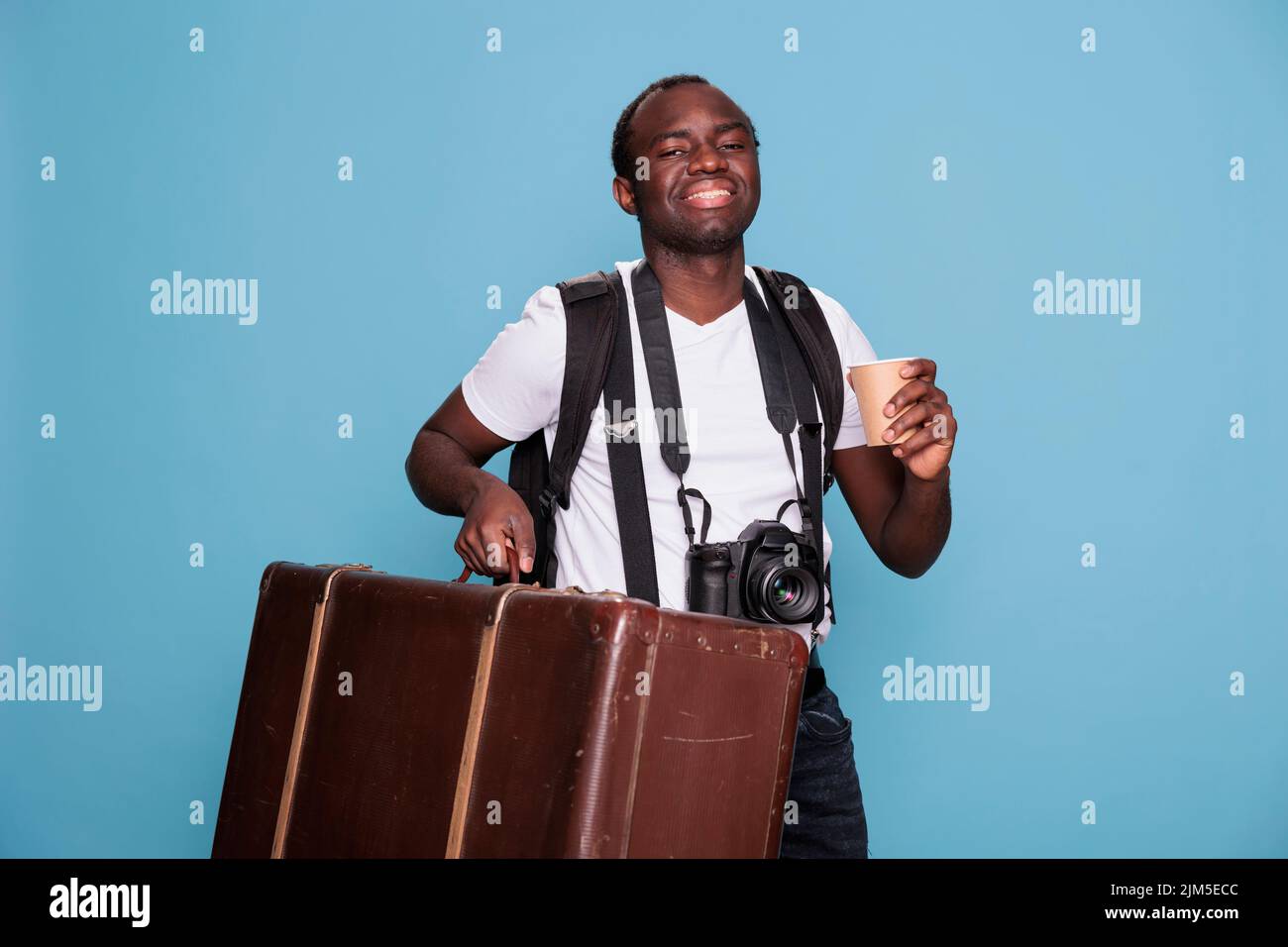 Happy photography enthusiast with luggage and DSLR camera getting ready