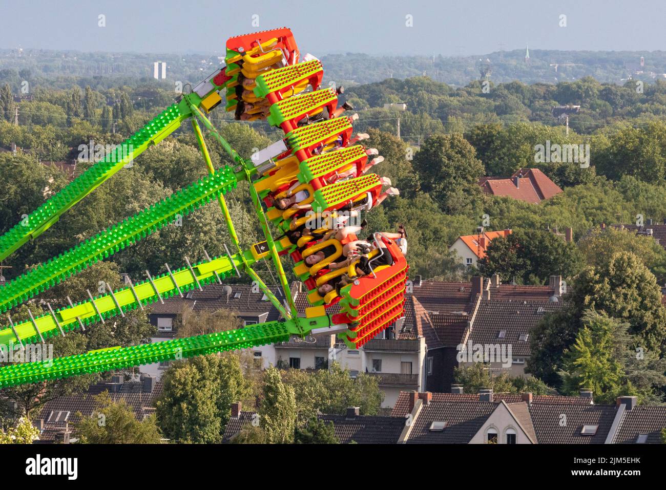 Cranger Kirmes, Herne, NRW, Germany, 04th Aug 2022. People on the 'Konga' ride high above Herne. Visitors enjoy the many attractions, roller coasters, beer halls, carousels and more at the Cranger Kirmes fun fair soft opening ahead of the official opening ceremony tomorrow. This is the first time it takes place since Covid restrictions took hold in 2020. The third largest fun-fair in Germany, and largest in Germany's most populous state NRW, usually attracts 4m  visitors over 10 days. It has a long tradition with fairs having taken place on the site since the early 18th century. Stock Photo