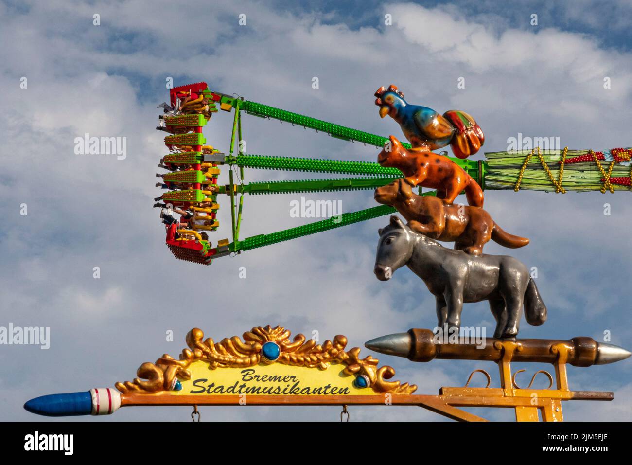 Cranger Kirmes, Herne, NRW, Germany, 04th Aug 2022. People on the 'Konga' ride appear to be watched by the 'Bremer Stadtmusikanten', popular animals from a German fairy tale. Visitors enjoy the many attractions, roller coasters, beer halls, carousels and more at the Cranger Kirmes fun fair soft opening ahead of the official opening ceremony tomorrow. This is the first time it takes place since Covid restrictions took hold in 2020. The third largest fun-fair in Germany, and largest in Germany's most populous state NRW, usually attracts 4m  visitors over 10 days. It has a long tradition with fai Stock Photo