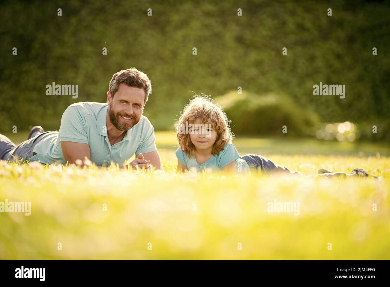family value. childhood and parenthood. parent relax with little child boy on grass. Stock Photo