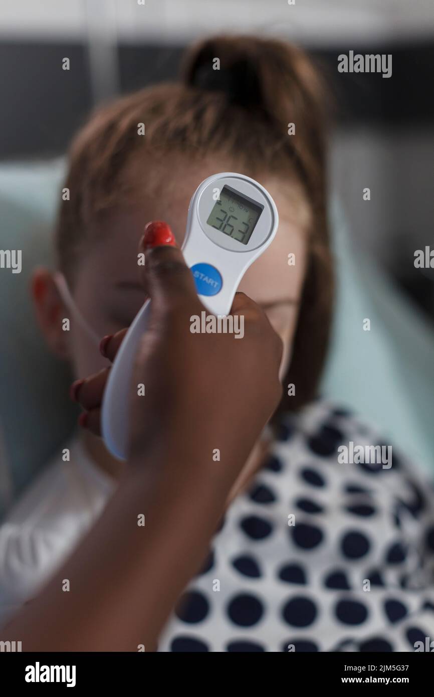 Close up shot of african american nurse measuring sick little girl body