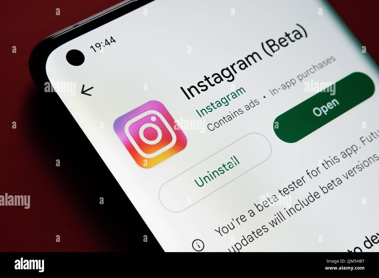 Instagram app seen in Google Play Store on the smartphone screen placed on red background. Close up photo with selective focus. Stafford, United Kingd Stock Photo