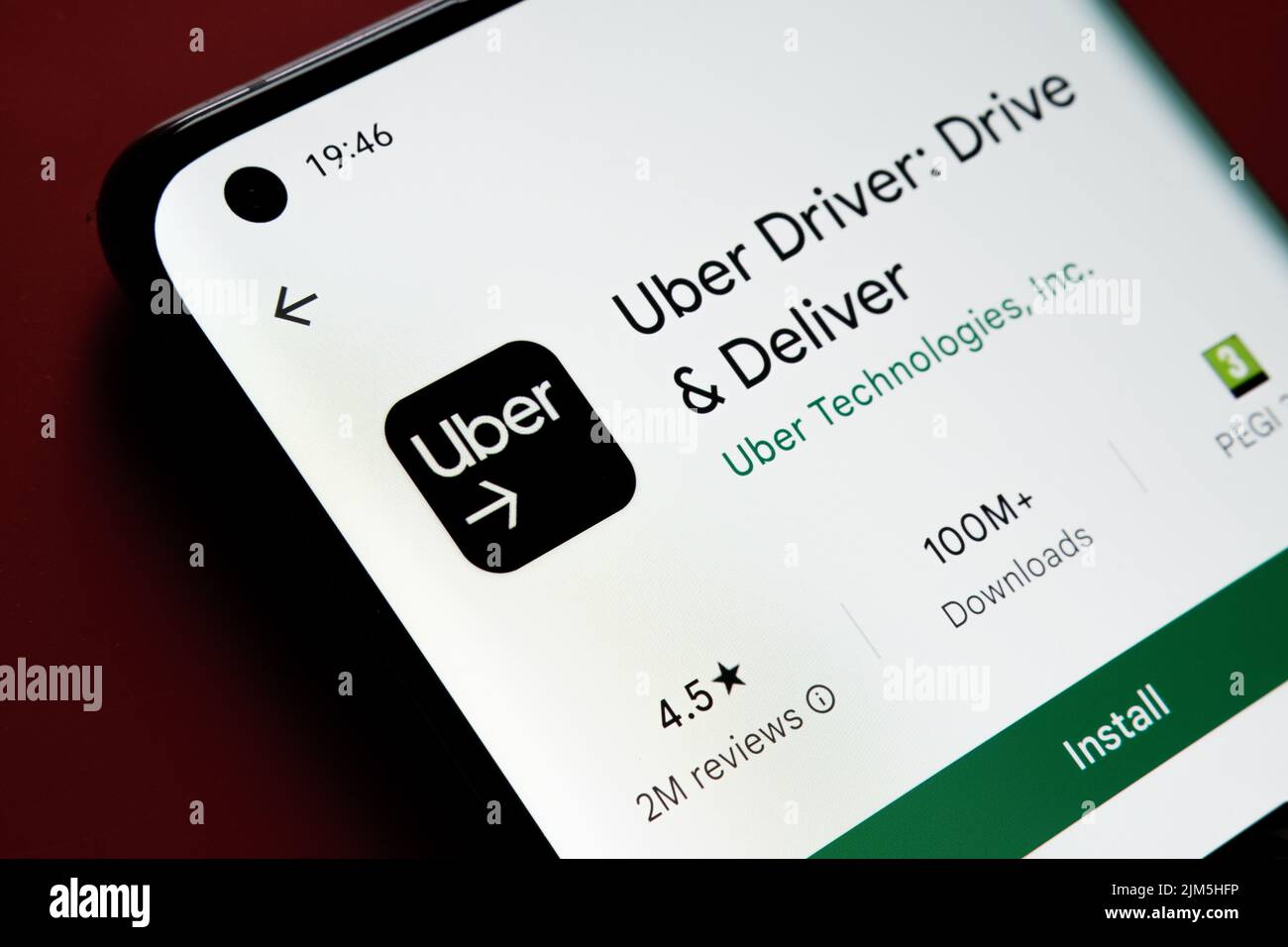 Uber Driver app seen in Google Play Store on the smartphone screen placed on red background. Close up photo with selective focus. Stafford, United Kin Stock Photo