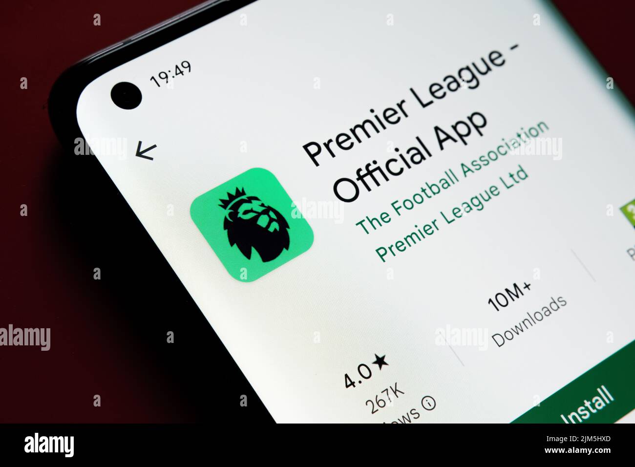 Premier League app seen in Google Play Store on the smartphone screen placed on red background. Close up photo with selective focus. Stafford, United Stock Photo