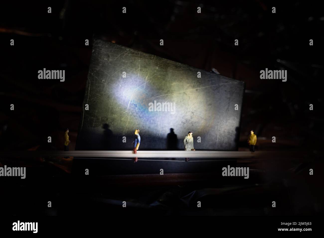 A closeup of small standing human figures on a black background with ...