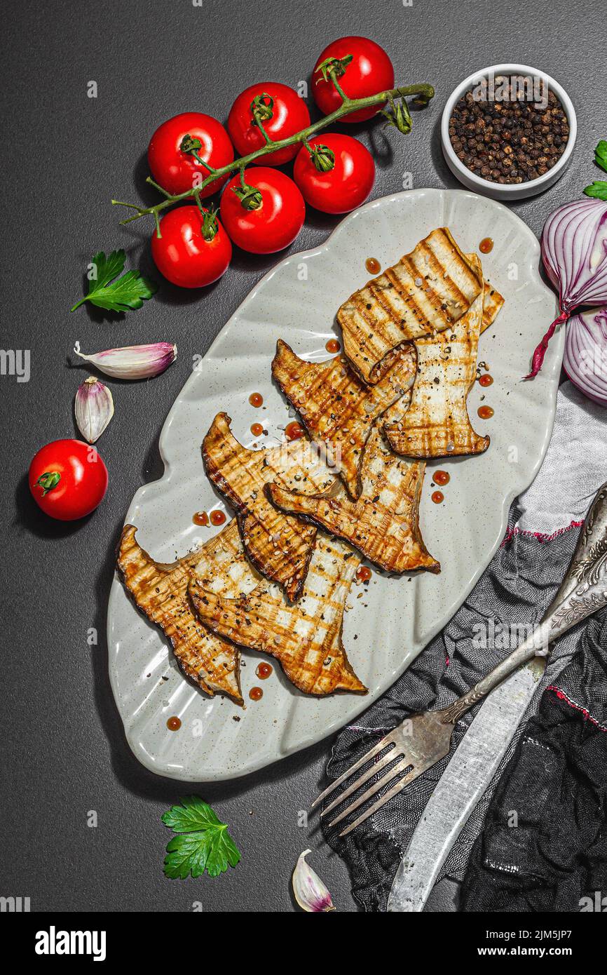 Fried slices Pleurotus eryngii mushrooms with balsamic sauce and sesame