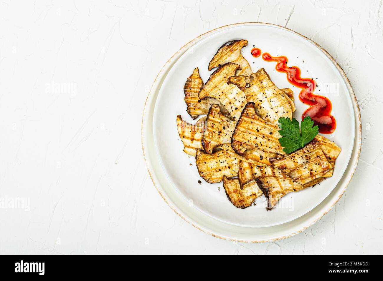 Fried slices Pleurotus eryngii mushrooms with sauce, spices and herbs