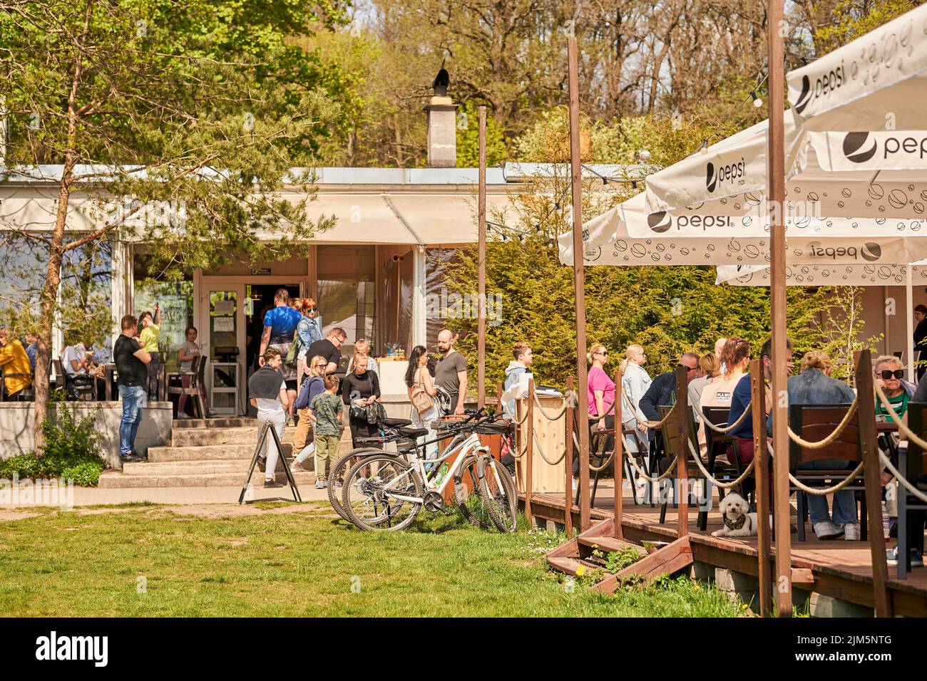 The people at the entrance of a restaurant by the Rusalka lake on a sunny spring day Stock Photo