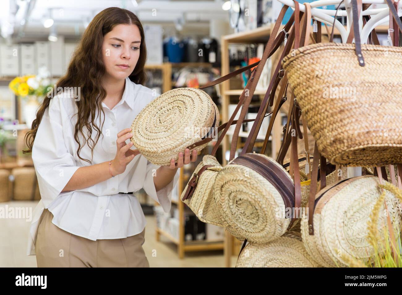 Woman buying straw bag at hardware store Stock Photo Alamy