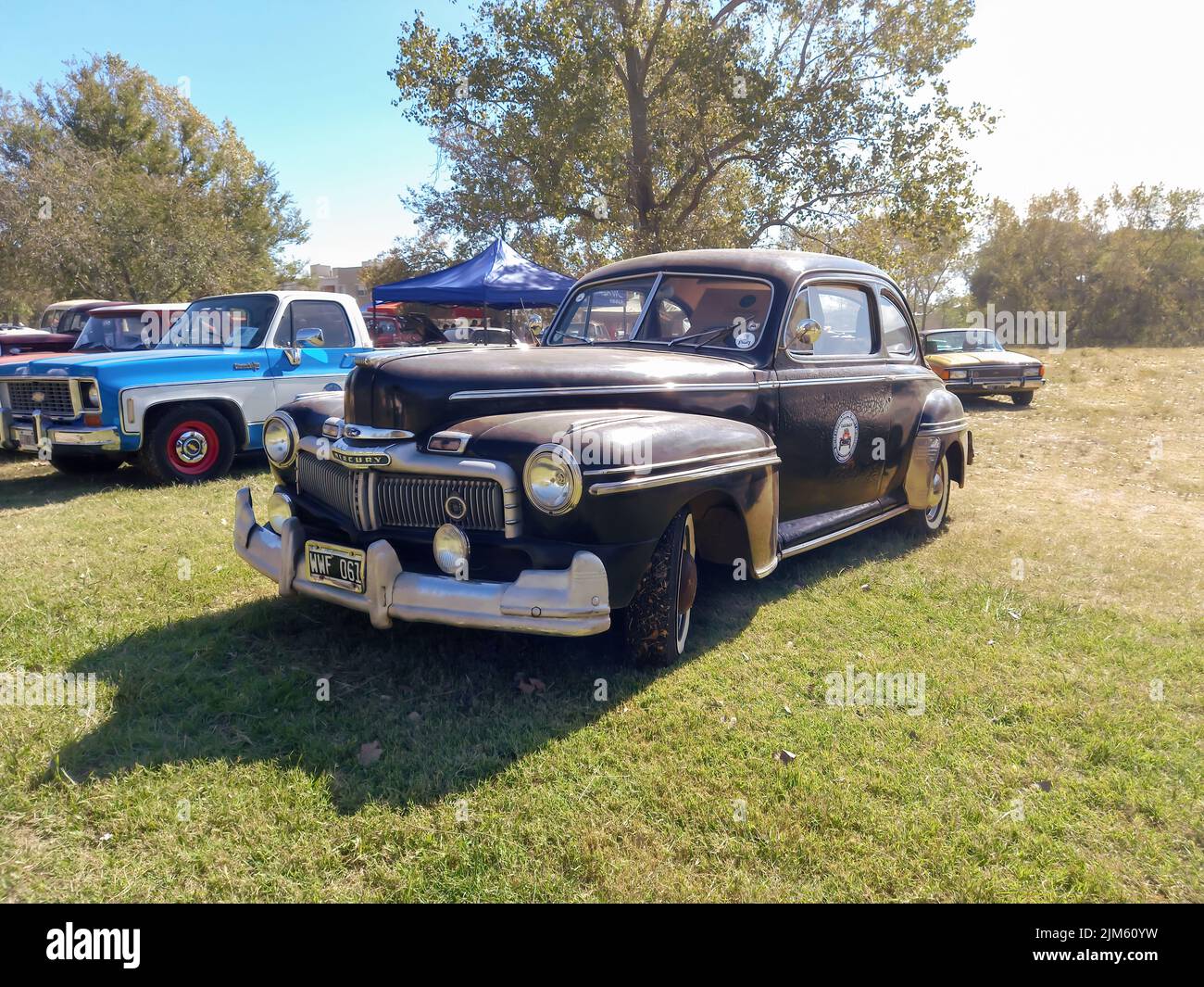 Old black Ford Mercury Eight coupe two door 1947 in the Countryside. Nature, grass, trees. Classic car show. Copyspace Stock Photo