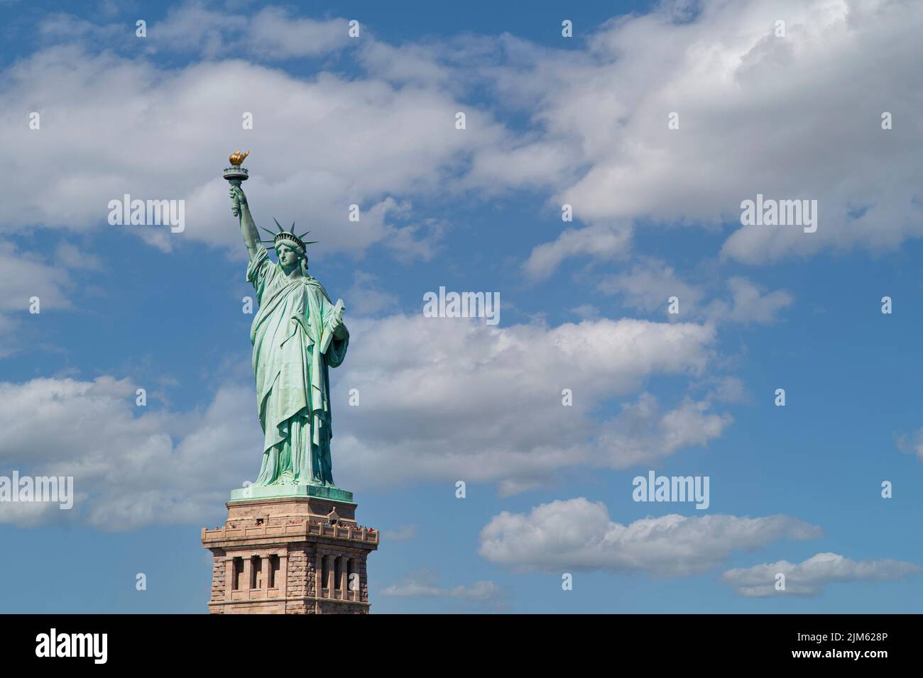 The Statue of Liberty rises out of Liberty Island in the waters that surround the city of New York. Stock Photo