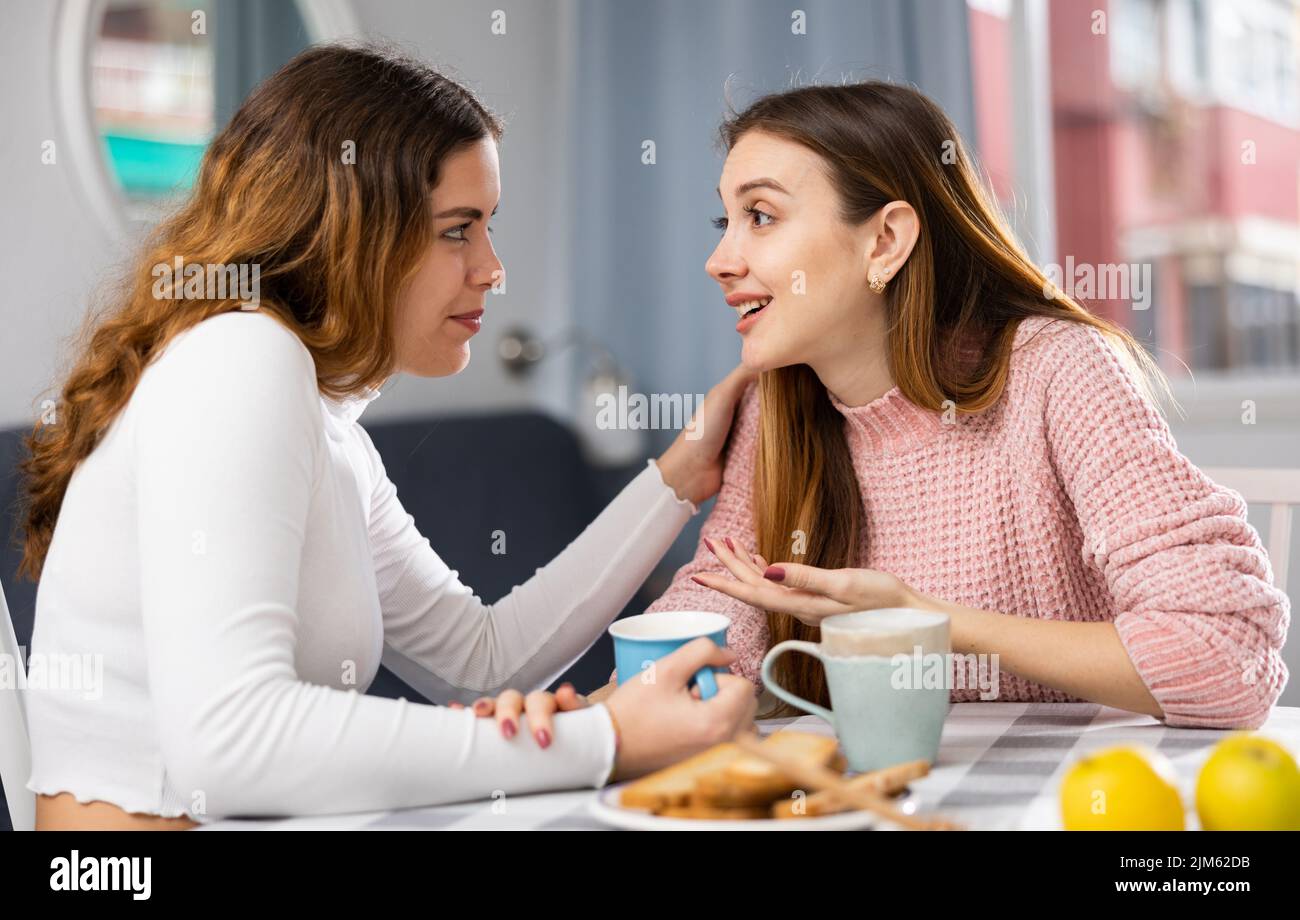 Two young women talking resting at home Stock Photo
