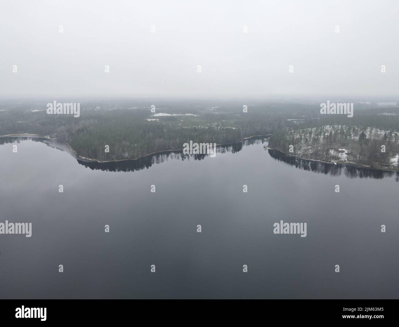 An areal view of a shore near forest all covered by snow Stock Photo