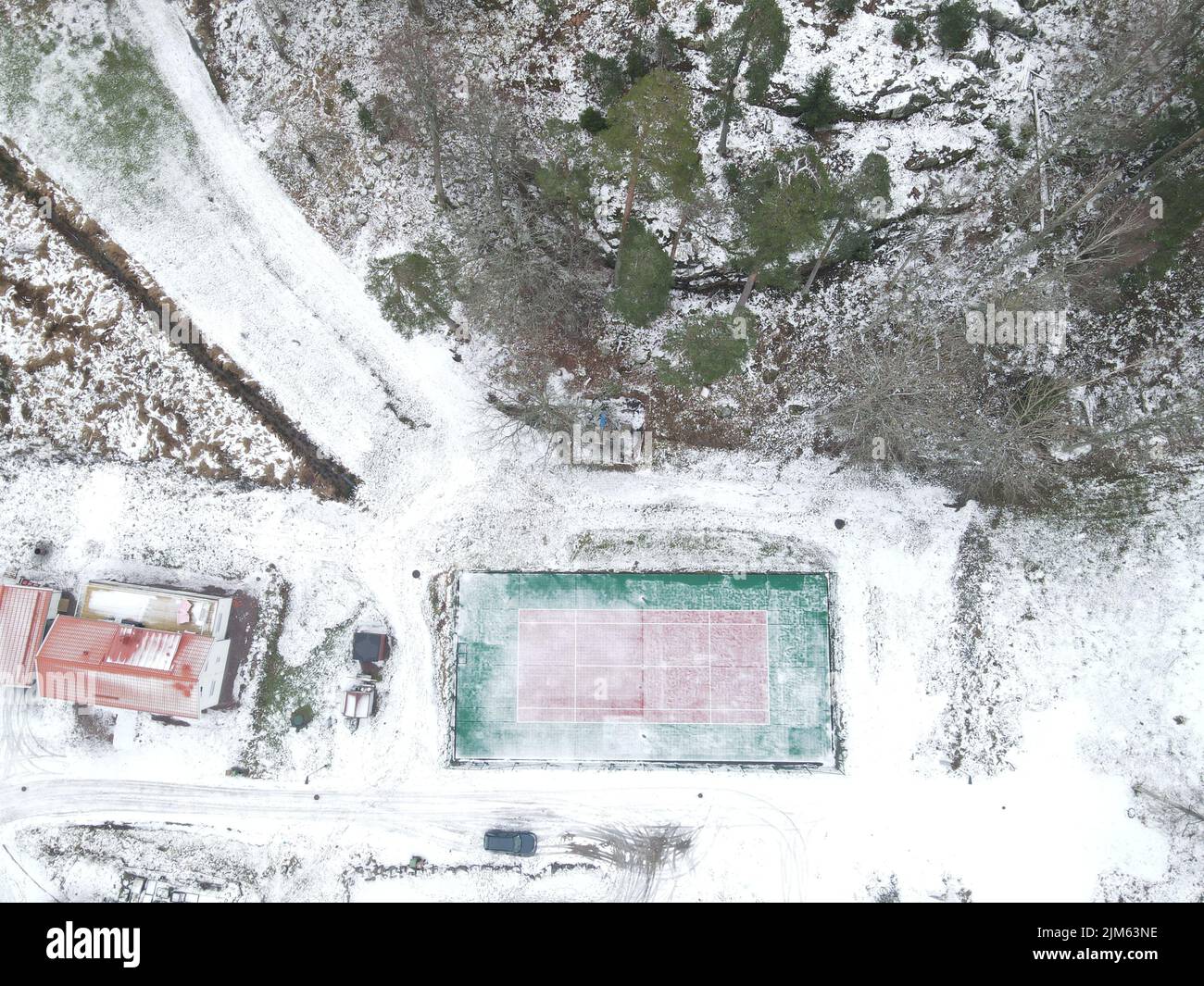 An areal view of a tennis court all covered by snow in a small town Stock Photo