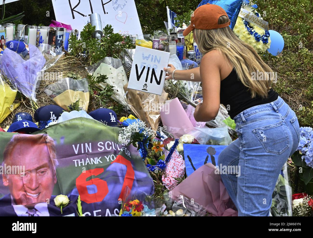 Los Angeles, United States. 04th Aug, 2022. Dodger fan Sam Fernandez places a 'Win For Vin' sign atop a makeshift memorial at the entrance of Dodger Stadium on Thursday, August 4, 2022. Vin Scully, the legendary Los Angeles Dodgers broadcaster, who serenaded baseball fans with his voice for nearly seven decades as the radio soundtrack for Los Angeles Dodgers games, died Tuesday at 94. Photo by Jim Ruymen/UPI Credit: UPI/Alamy Live News Stock Photo