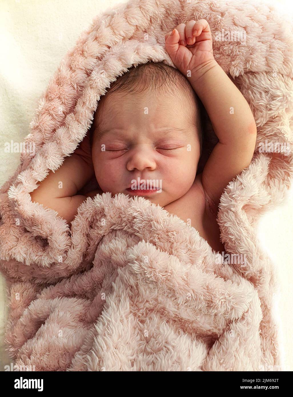 A vertical shot of a beautiful baby sleeping peacefully in a pale