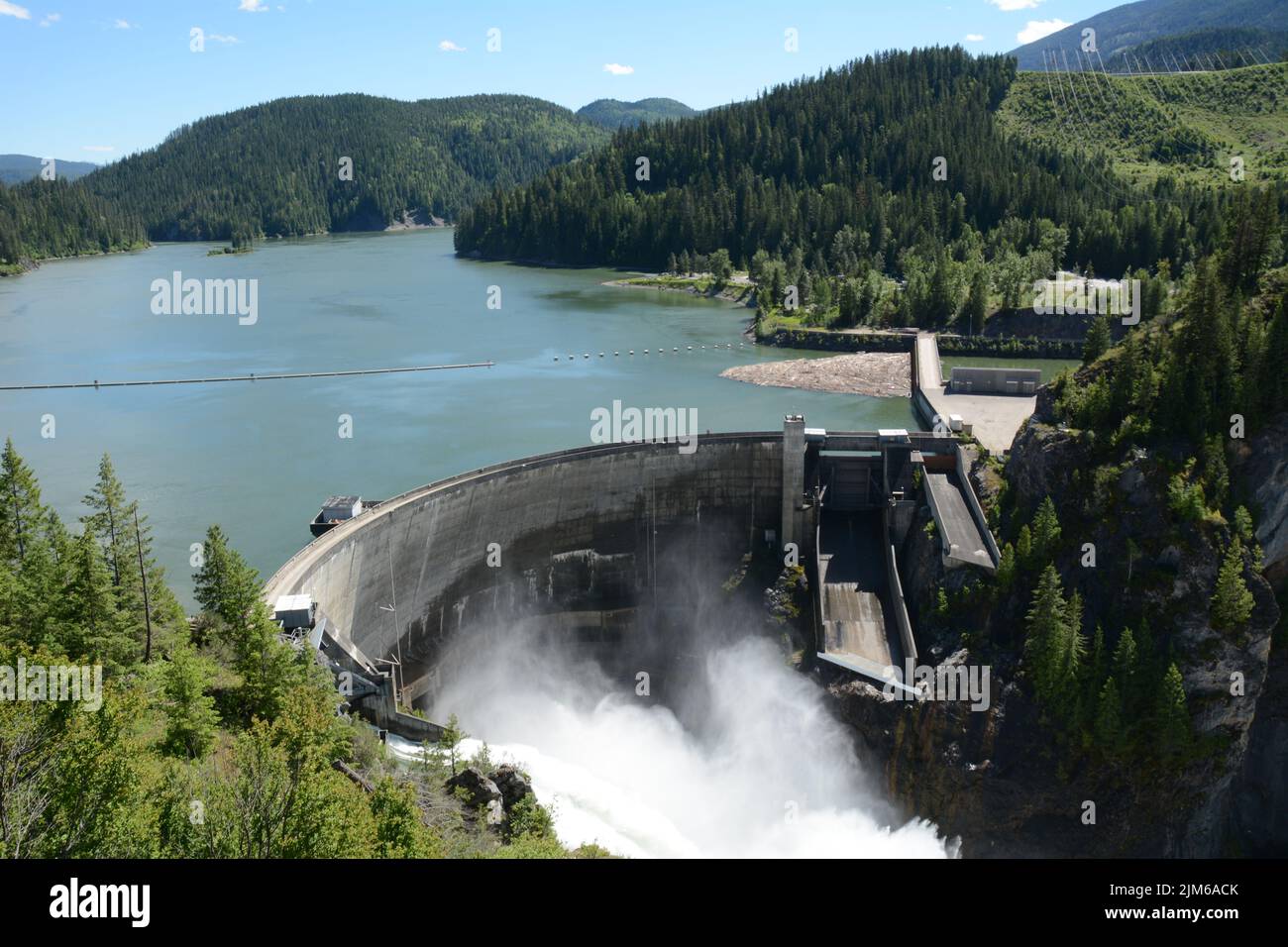 Aerial view of the concrete arch hydro-electric Boundary Dam spilling water on the Pend-Oreille River, flowing into Canada, in Washington State, USA. Stock Photo