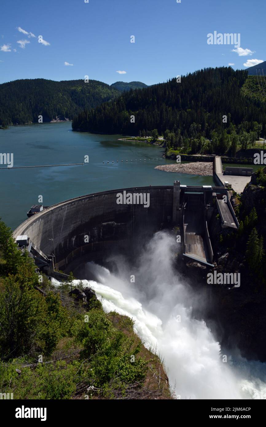 Aerial view of the concrete arch hydro-electric Boundary Dam spilling water on the Pend-Oreille River, flowing into Canada, in Washington State, USA. Stock Photo