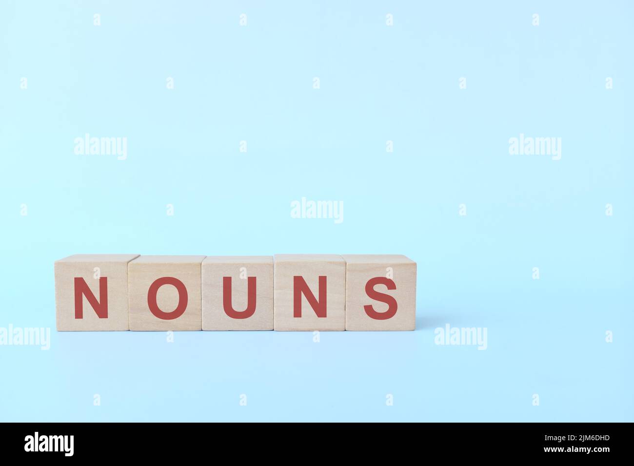Noun or nouns concept in English grammar education. Wooden block