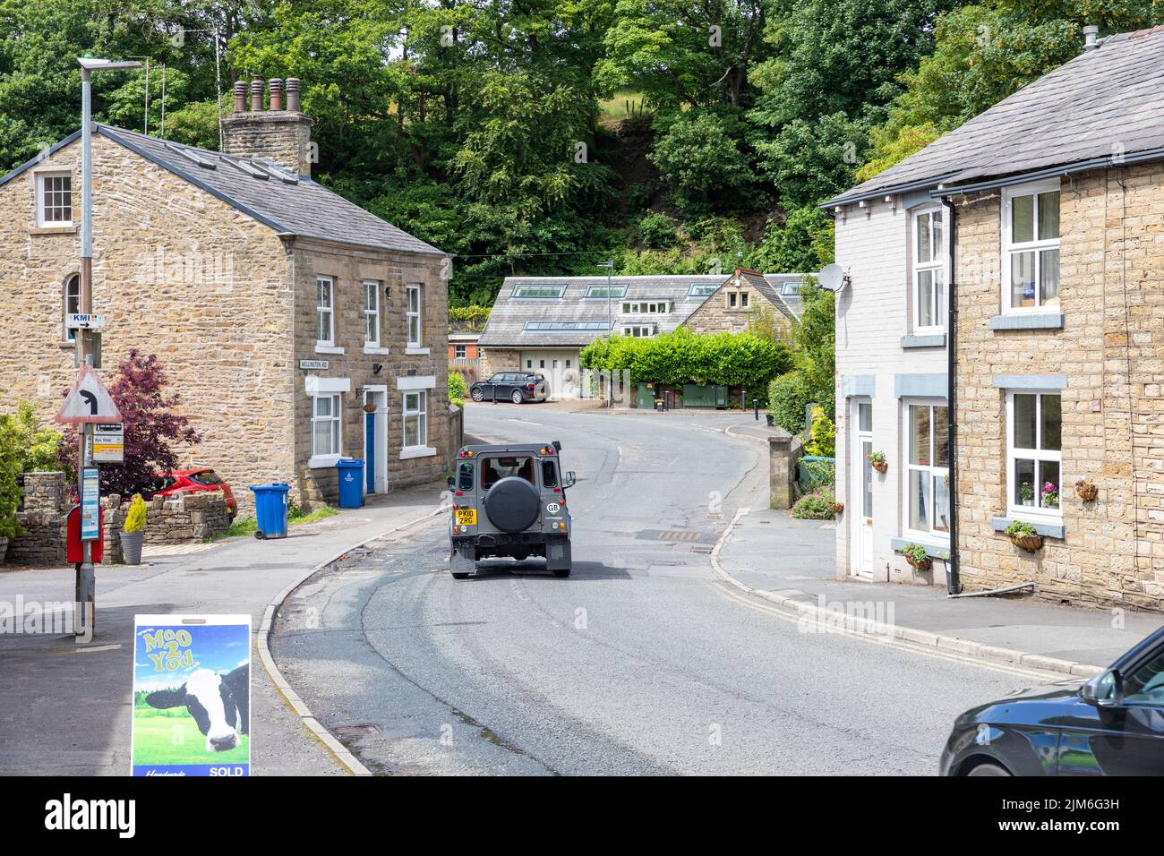 Land Rover defender driving through Edgworth village on the Bolton Road,Lancashire,England,UK, summers day Stock Photo