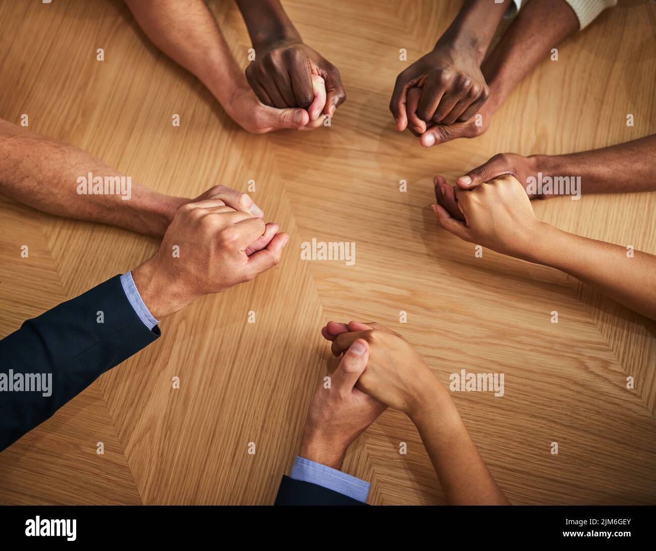 United, support and trust by business people holding hands in a circle from above. Community, teamwork and collaborating professional coworkers Stock Photo