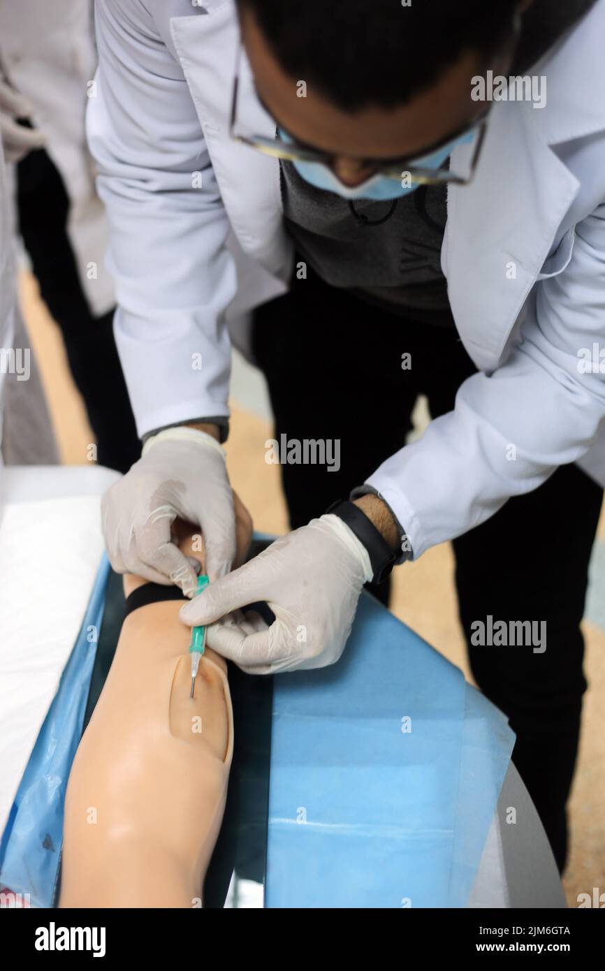 Injrue Mask A medical student wearing a protective face mask is seen performing ...
