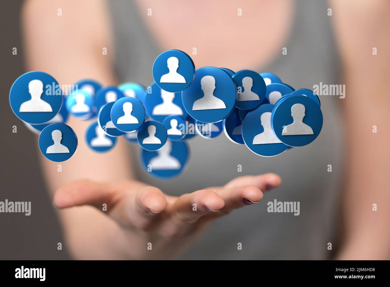 A businessman holding a floating digital render of profile icons ...